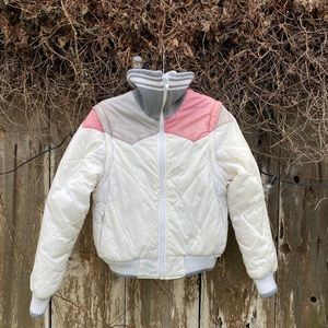 Reversible puffer jacket with detachable sleeves.